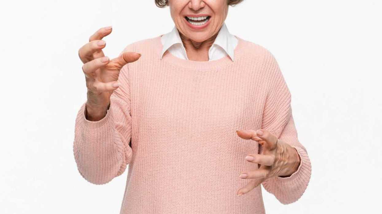 Angry mature woman on white background. Portrait of elderly senior lady grandmother feeling frustrated expressing anger, mad, upset, hostile, shouting isolated on light background.