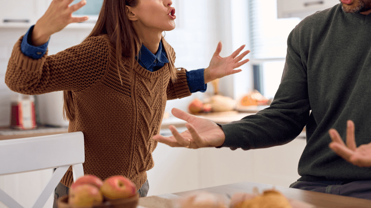 angry woman berates man in kitchen