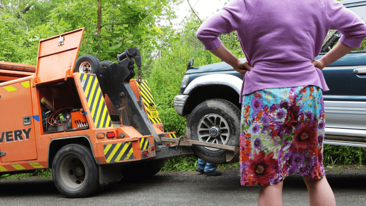 Angry woman observing tow truck