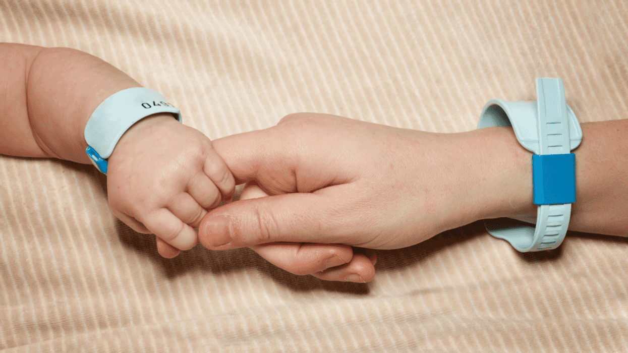 Baby holding their parent's hand