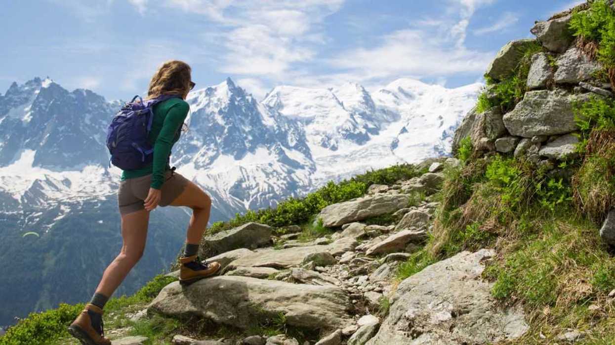 back shot of a woman hiking in the mountains.