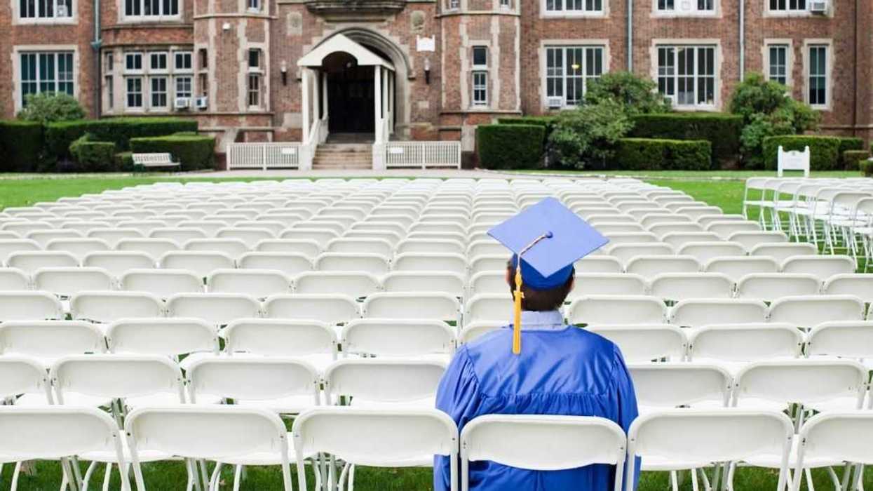 Backview shot of a graduate sitting alone.