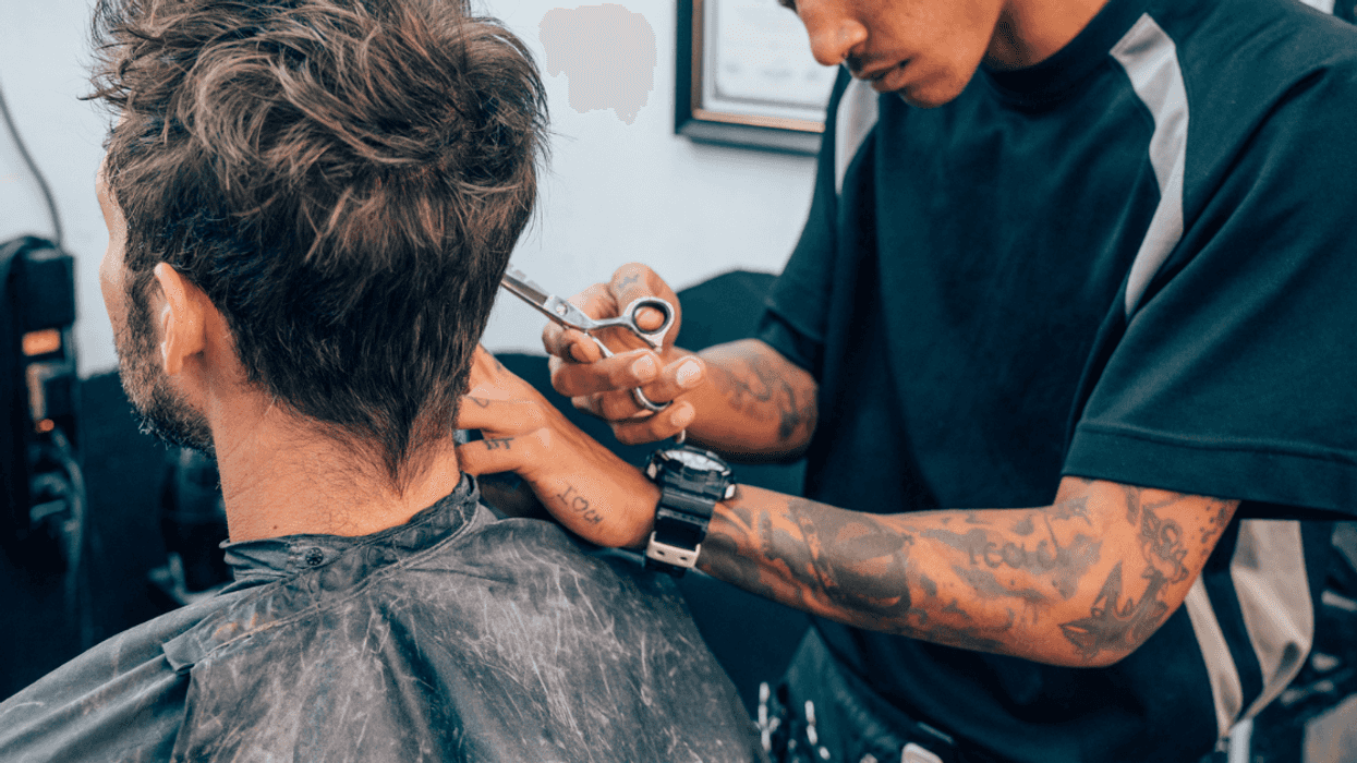 barber cuts a customer's hair