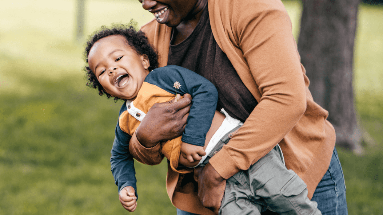 Black mother playing with her son at a park