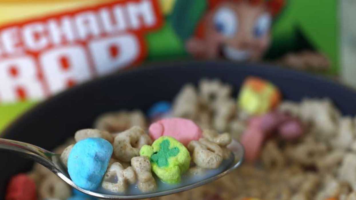 Blurred shot of a box of cereal. Up close, not blurred, we see a spoon full of cereal.