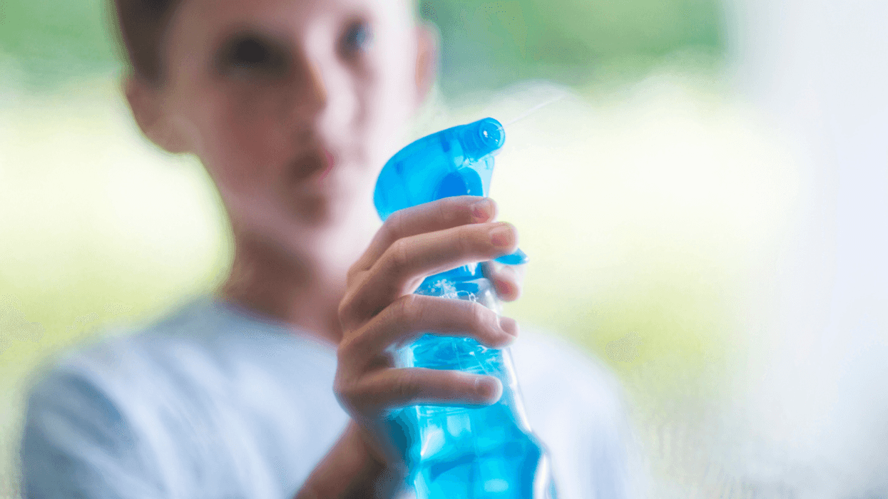 Boy spraying liquid with a spray bottle