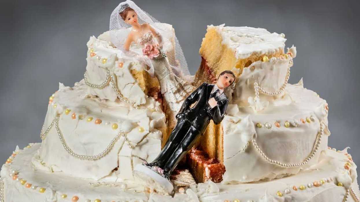 Bride and groom figurines collapsed in a ruined wedding cake.