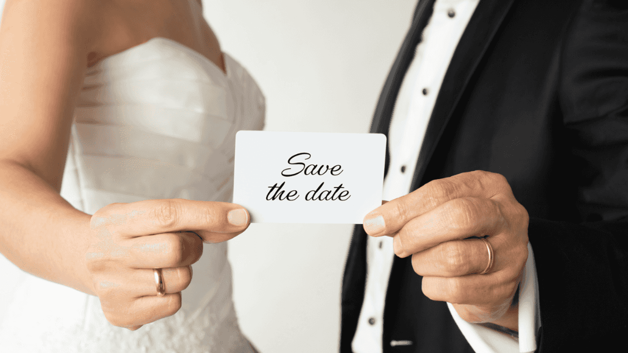 bride and groom holding 'save the date' card
