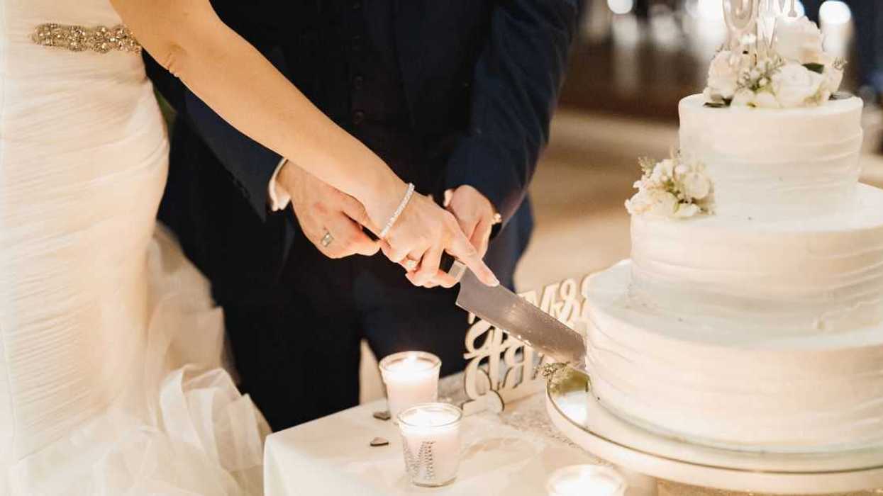 Bride and groom slicing wedding cake