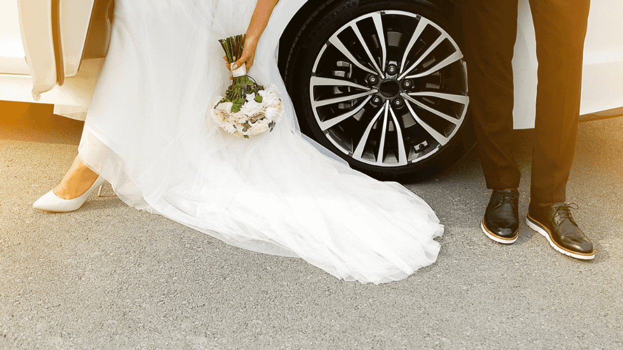 Bride and groom standing near car