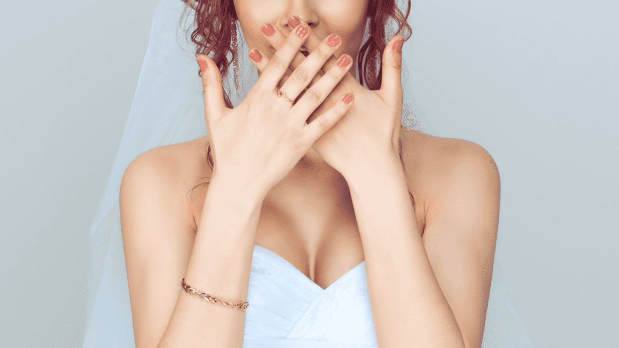 Bride covering her mouth with her hands.