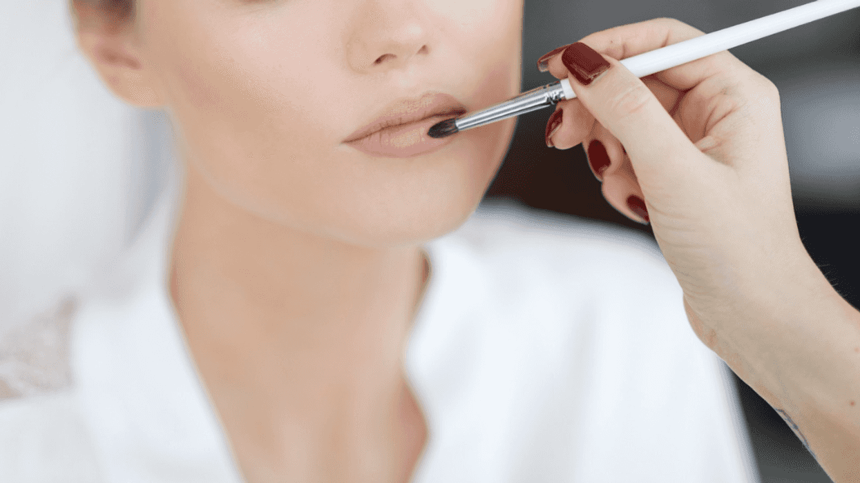 bride gets her makeup applied