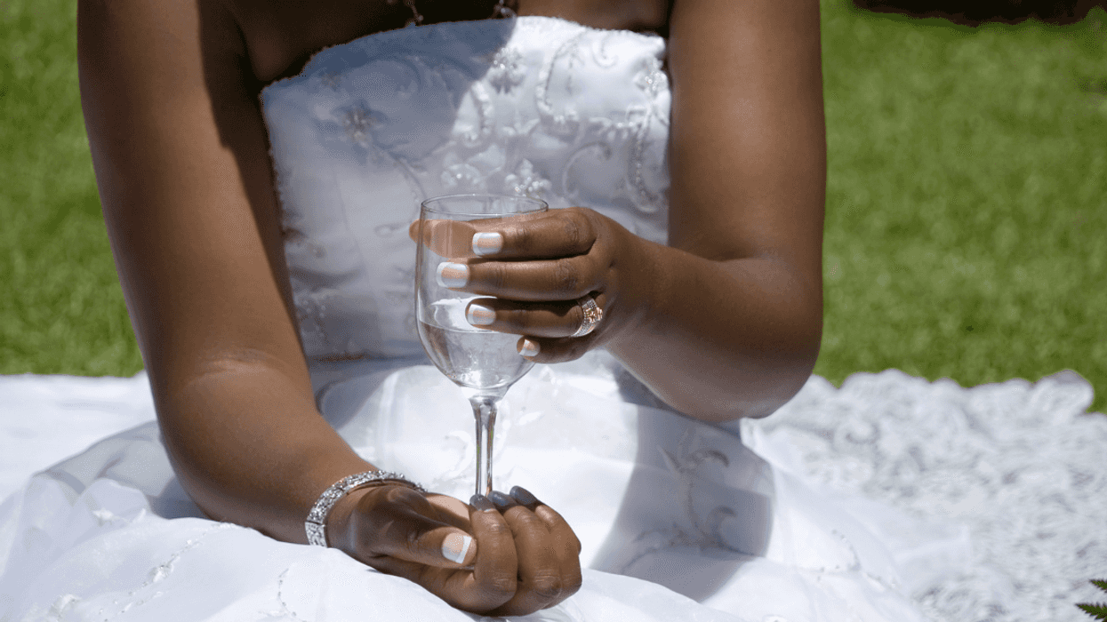 Bride holding a champagne glass filled with water