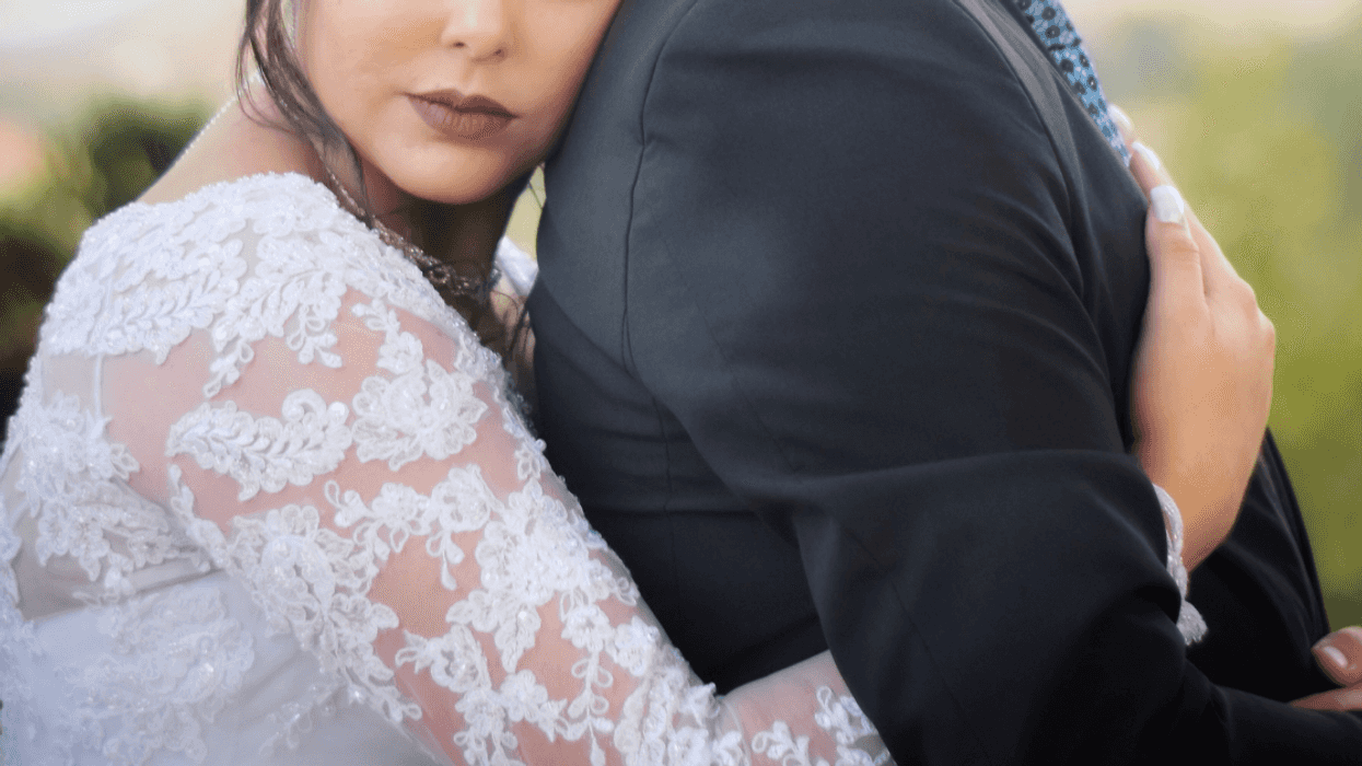 bride hugs her groom from behind