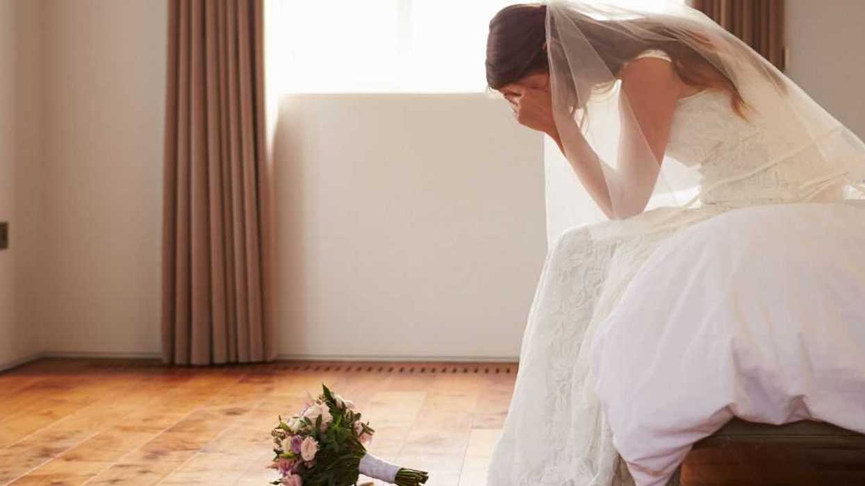 Bride In bedroom with her hands in her hands, her bouquet on the floor