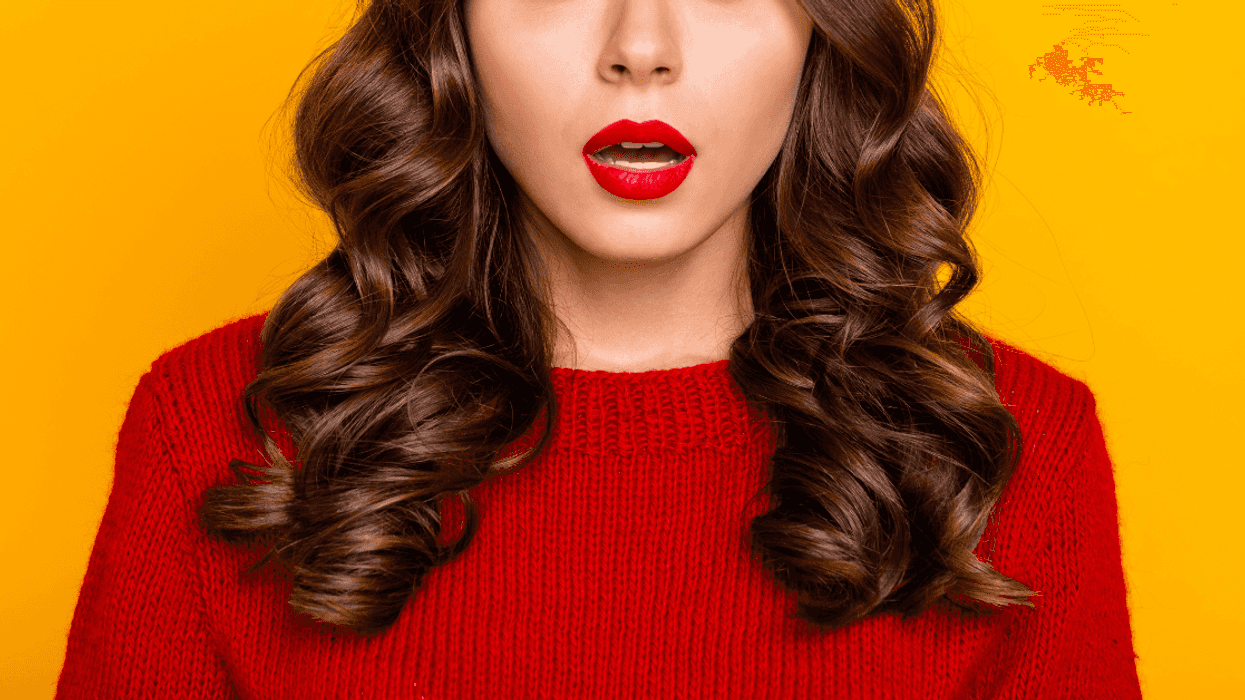 brown haired woman in red sweater with shocked expression