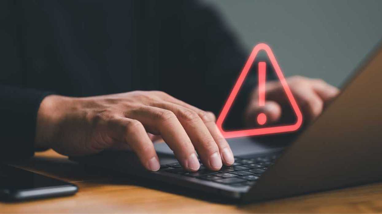 Businessman or it staff , programmer, developer using computer laptop with triangle caution warning sign for notification error and maintenance concept.