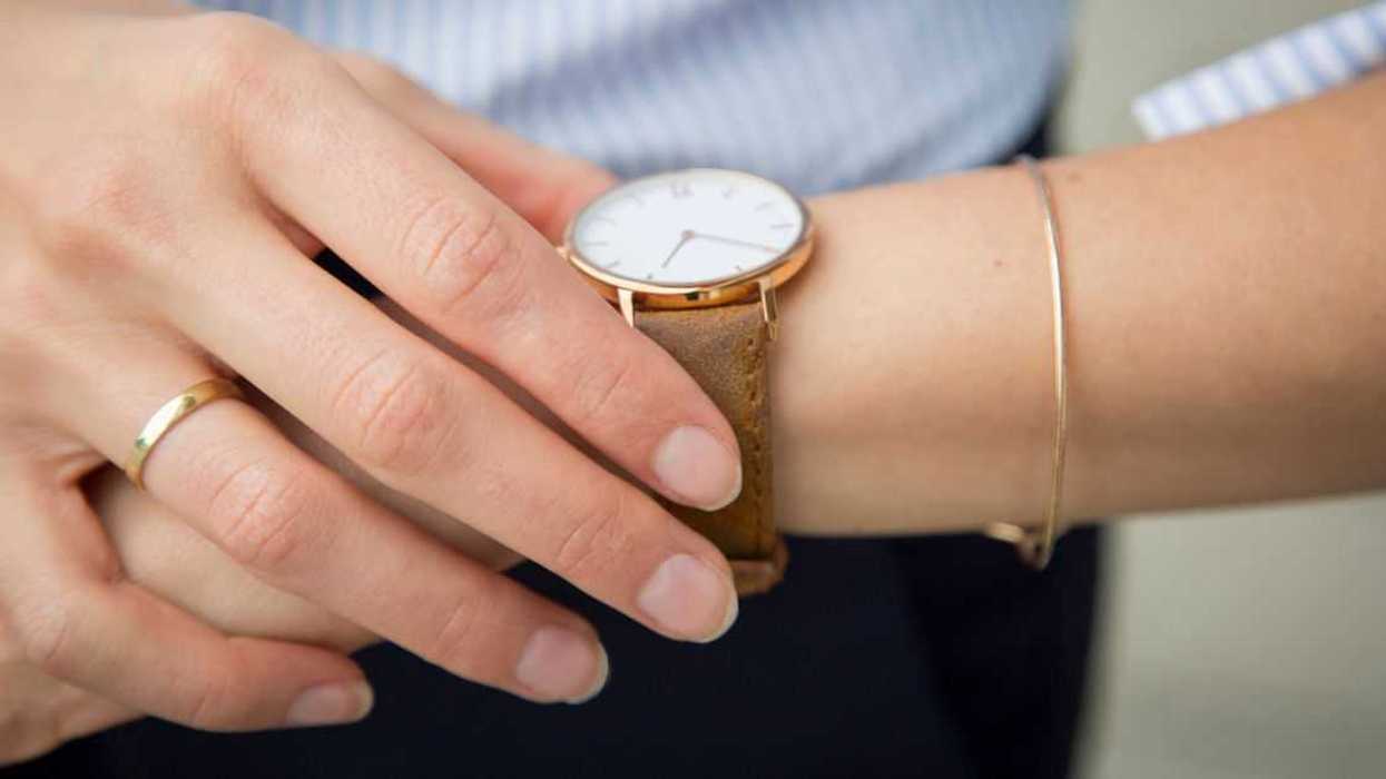 Businesswoman wearing wrist watch, close-up.