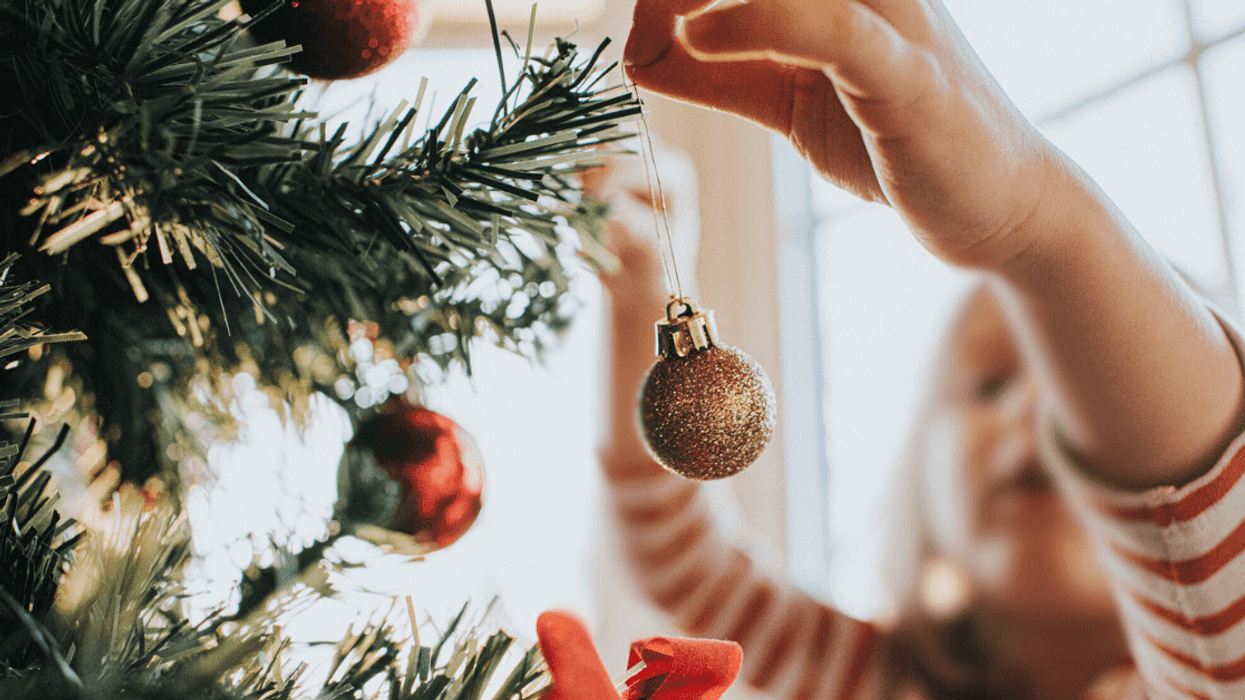 child decorating Christmas tree