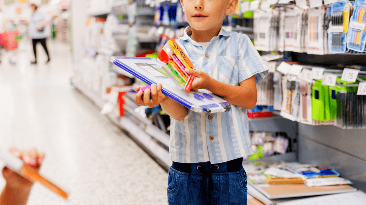 child getting school supplies at store