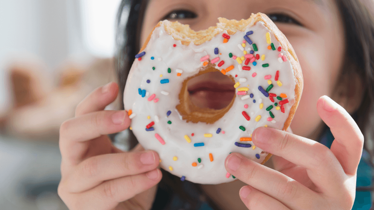 child holding donut with bite in it