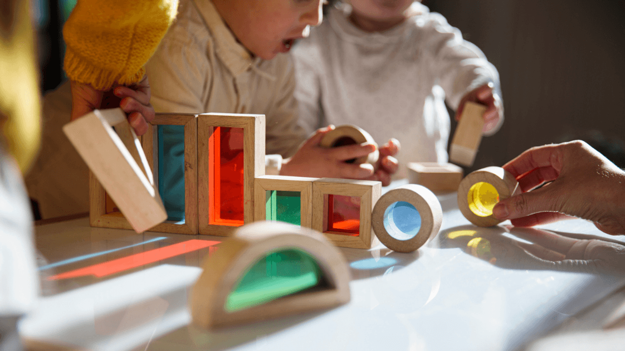 Children playing at a table playing with blocks.