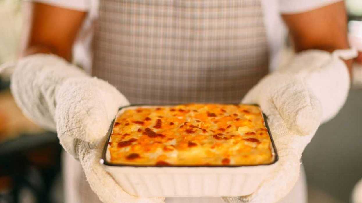 Close-up of a chef presenting a baked mac and cheese.