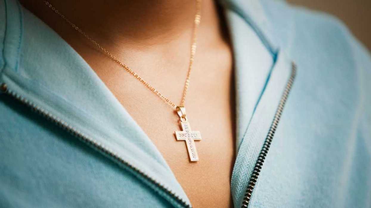 Close up of a cross necklace on woman.