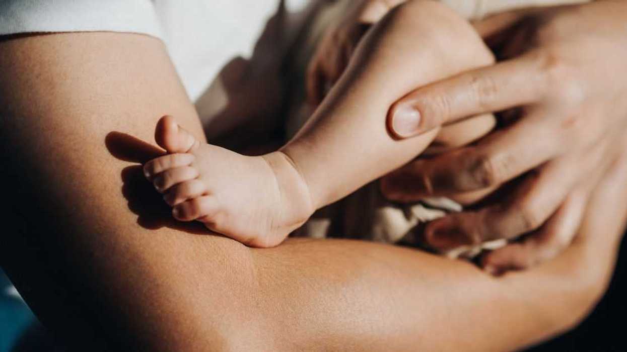 Close up of a loving young father carrying his newborn baby daughter in arms. Bonding moment of father and daughter.