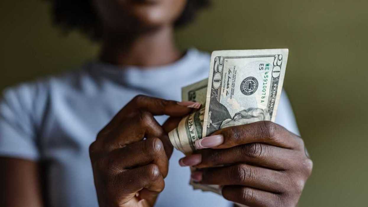 Close up of a woman counting money.