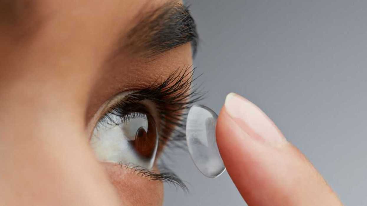 Close-up of a woman putting in a contact lens.