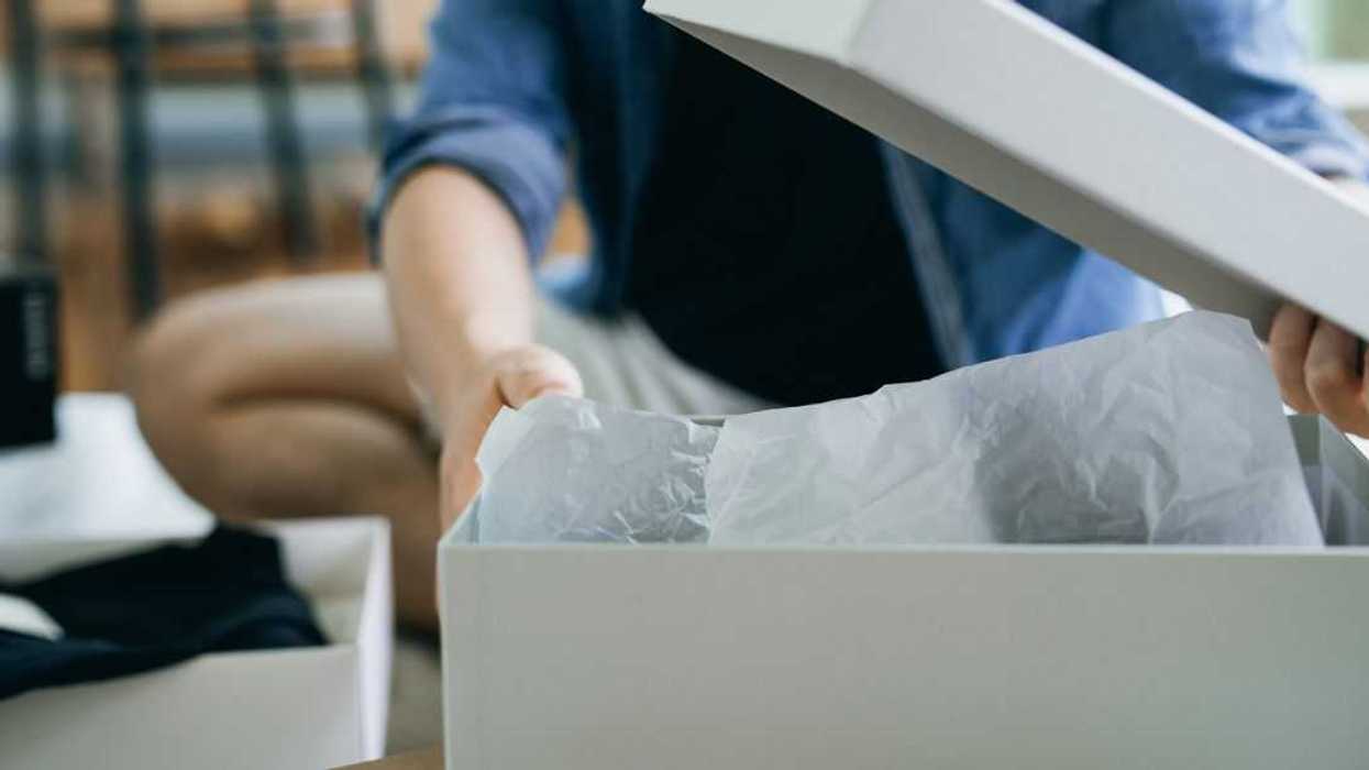 Close up of an unidentified man unboxing new purchase from cardboard box.