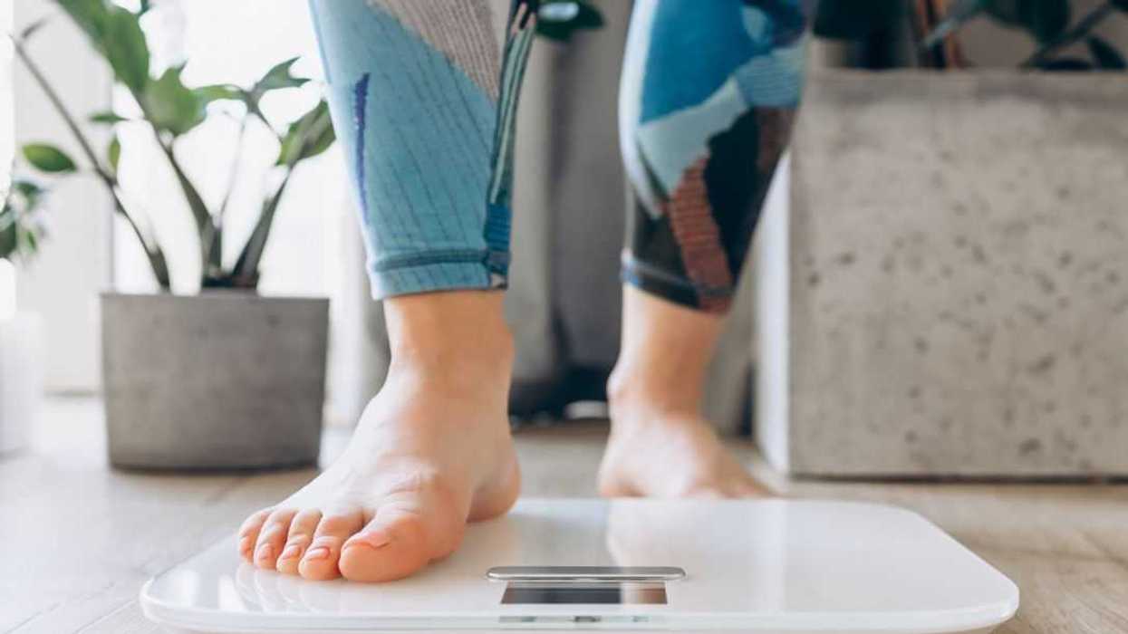 Close-up of bare feet stepping onto a digital scale, symbolizing health, fitness, and mindfulness in a modern home setting.