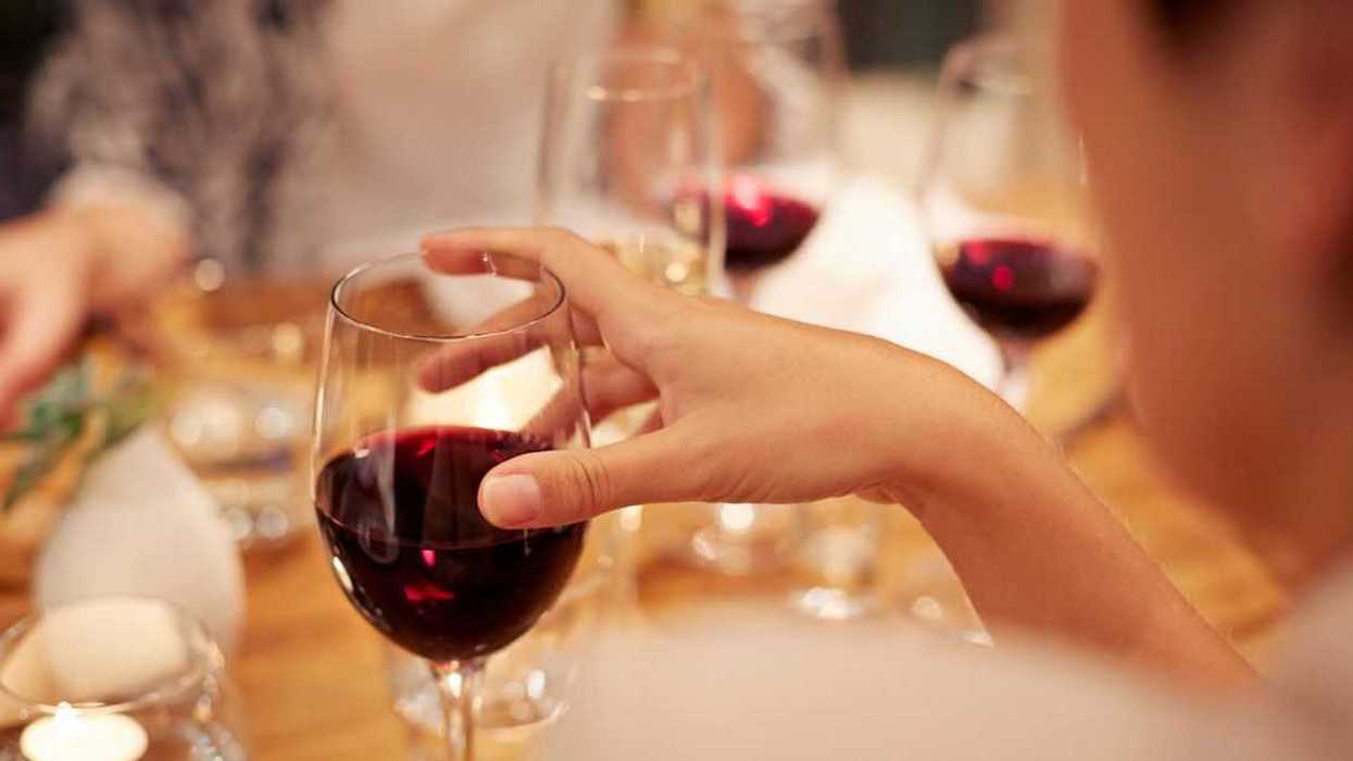 Close-up of female holding glass with red wine.