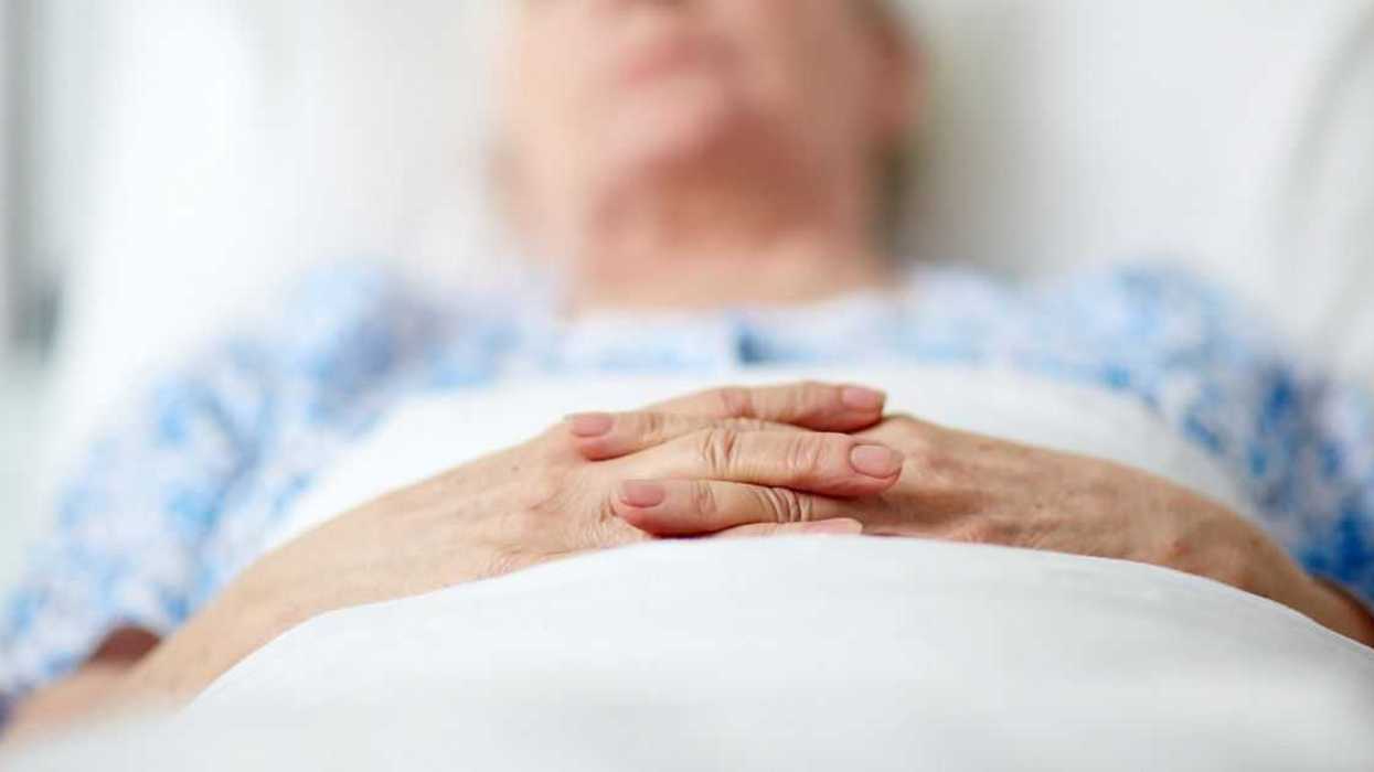 Close-up of hands of senior woman lying in hospital ward.