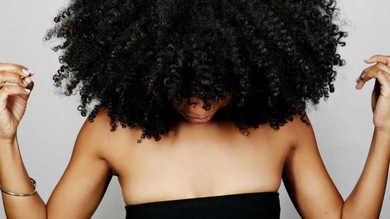 Close up of mixed race woman with curly hair looking down