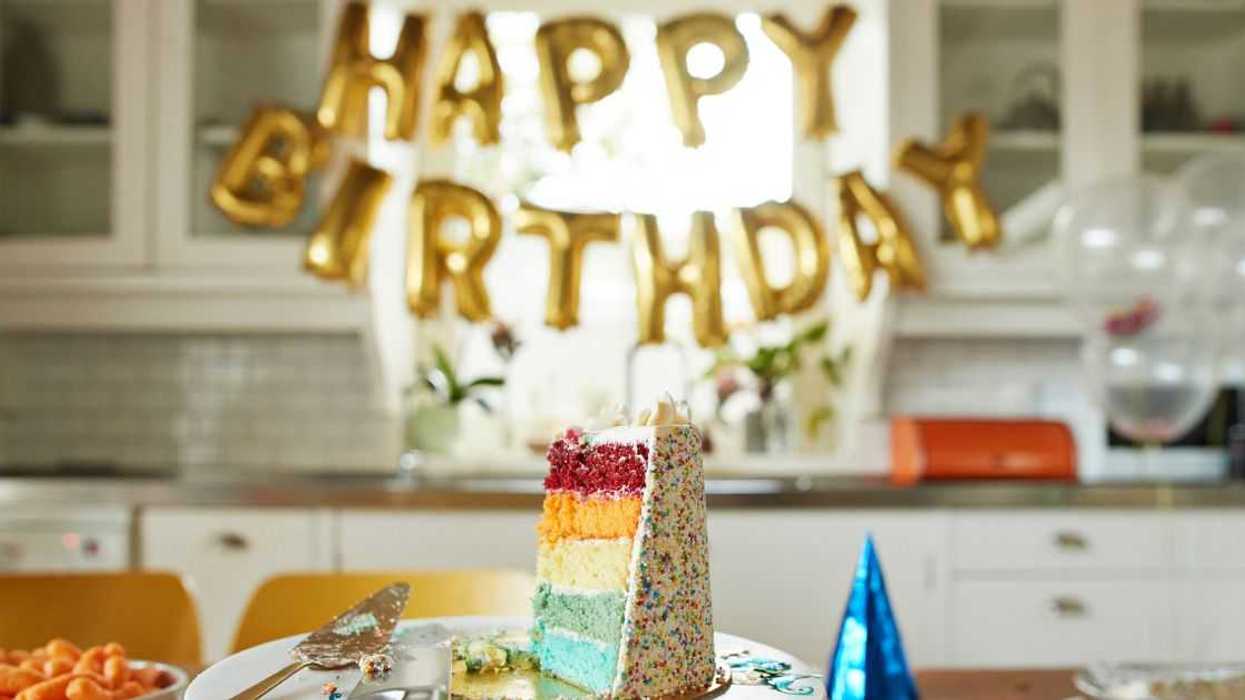 Close-up of multi-colored cake slice on table during birthday party.