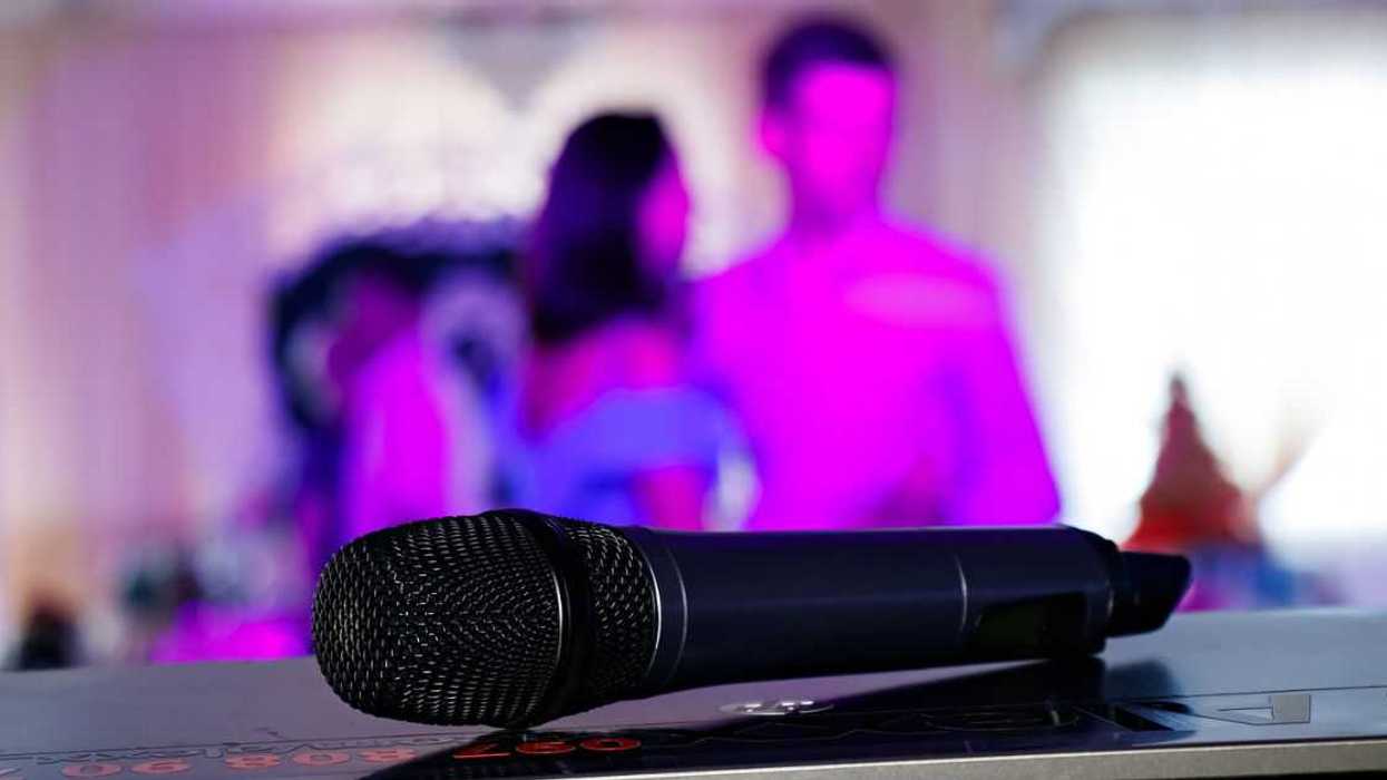 Close up on a microphone, on stage of a business meeting or event with flare light effect and copyspace.