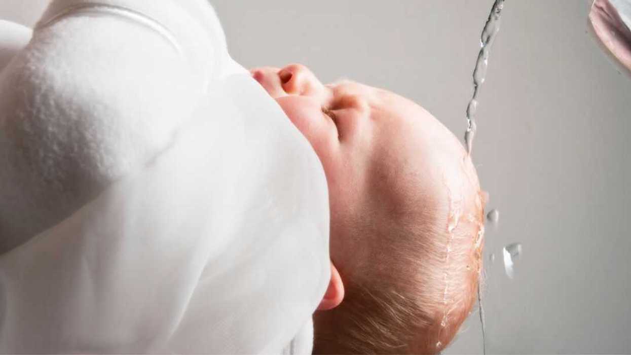 Close-up shot of a baby being baptized.