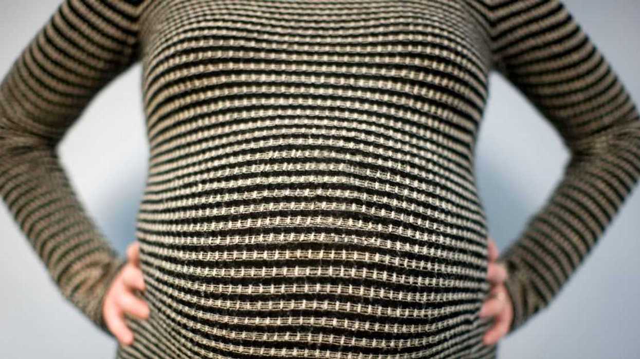 Close- up shot of a pregnant woman's stomach.