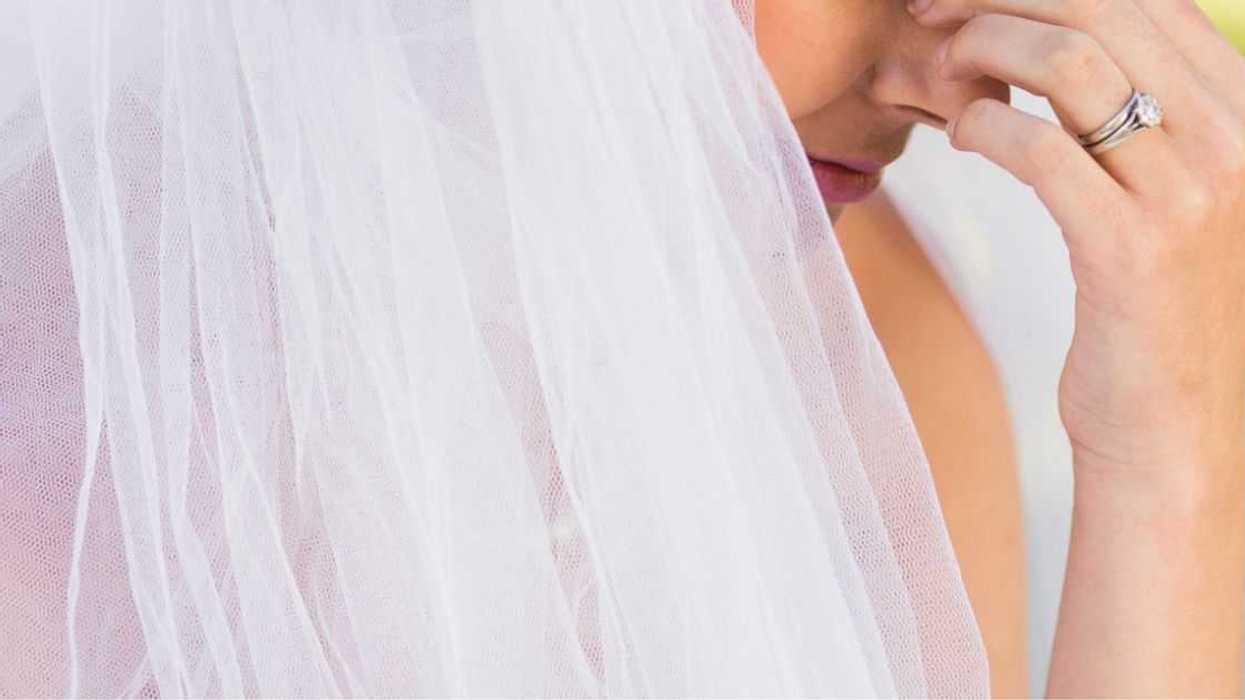 Close-up, side view of a beautiful, worried bride at the park.
