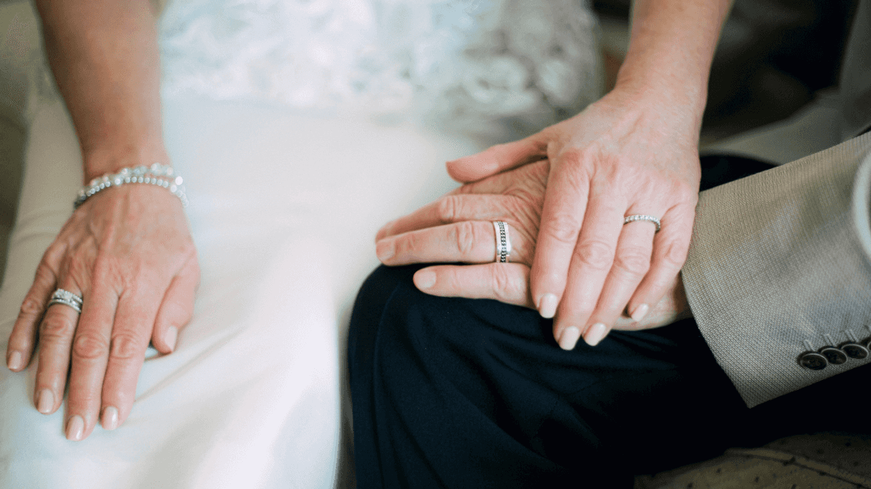closeup of the hands of an older bride and groom