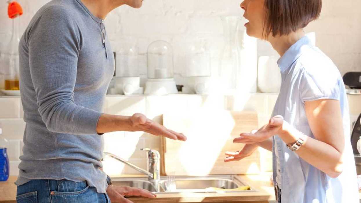 Couple having an animated discussion in the kitchen.