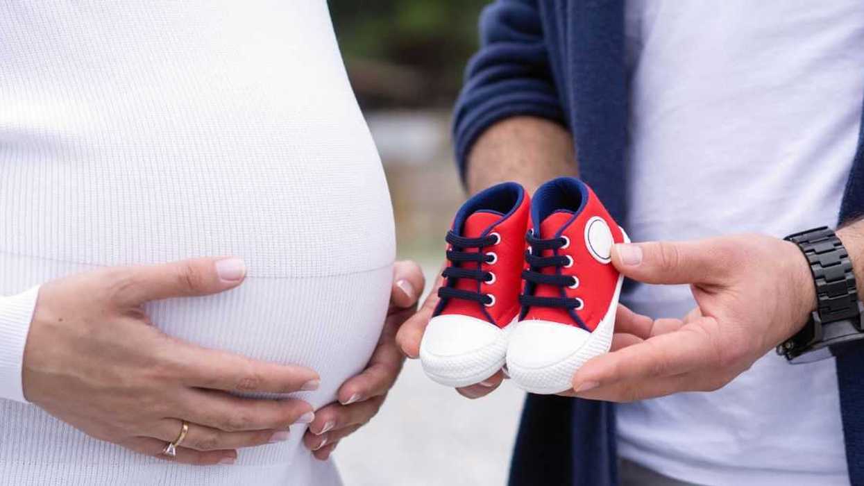 Couple holding baby boy shoes