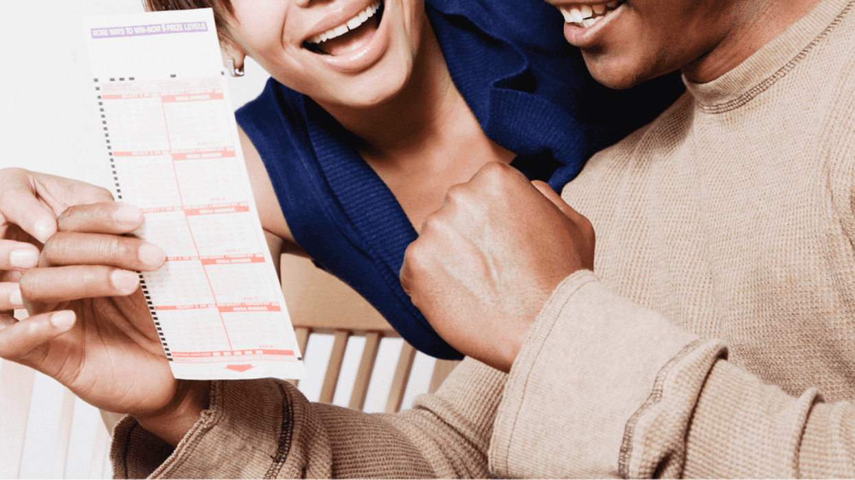 Couple holding lottery ticket.