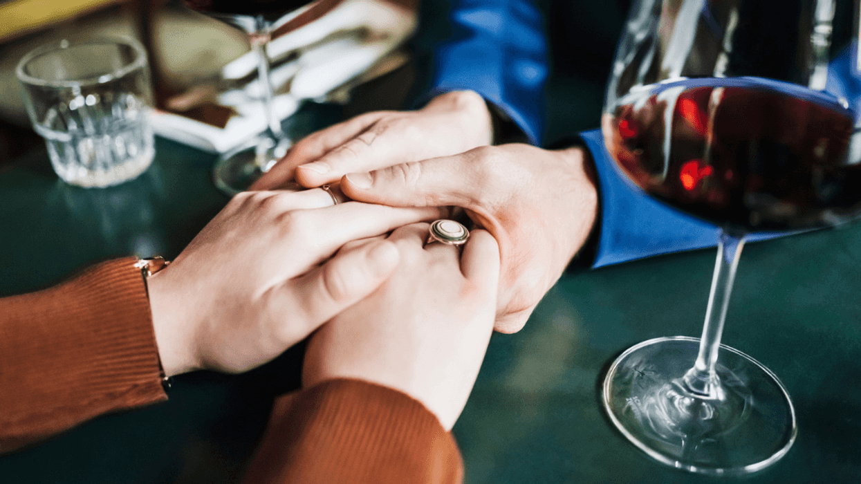 couple holds hands on table