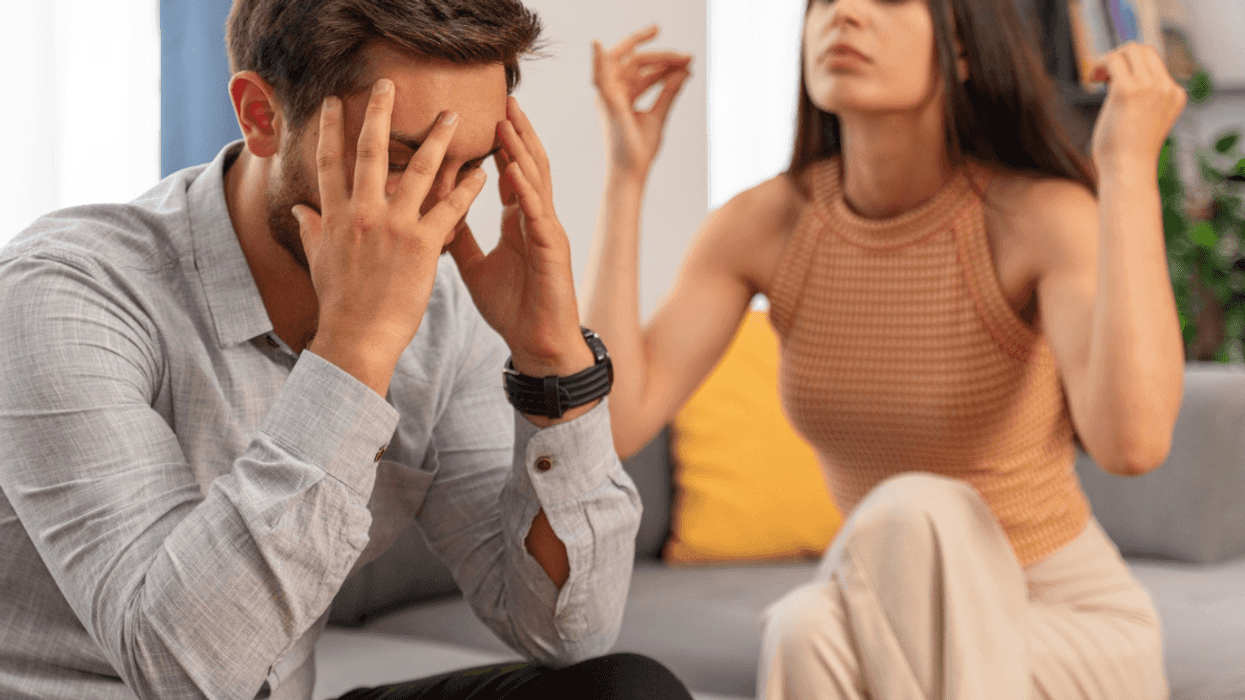 couple seated on couch arguing