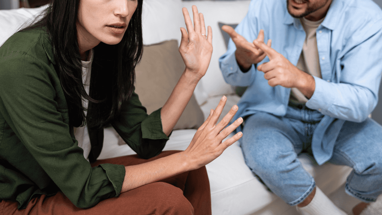 couple seated on couch arguing