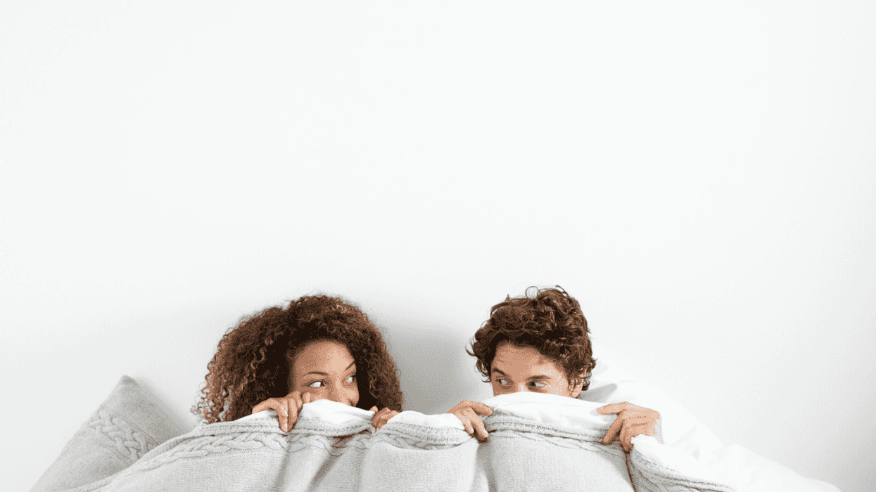 Couple under the covers in bed