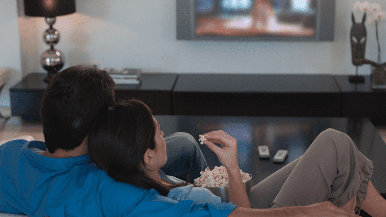 Couple watching tv and eating popcorn
